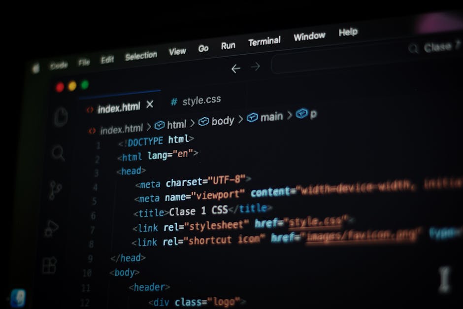 A person working on a laptop with a black screen displaying lines of colorful code in green, blue, and white text, situated on a dark, reflective surface. The individual's hands are visible, with one 